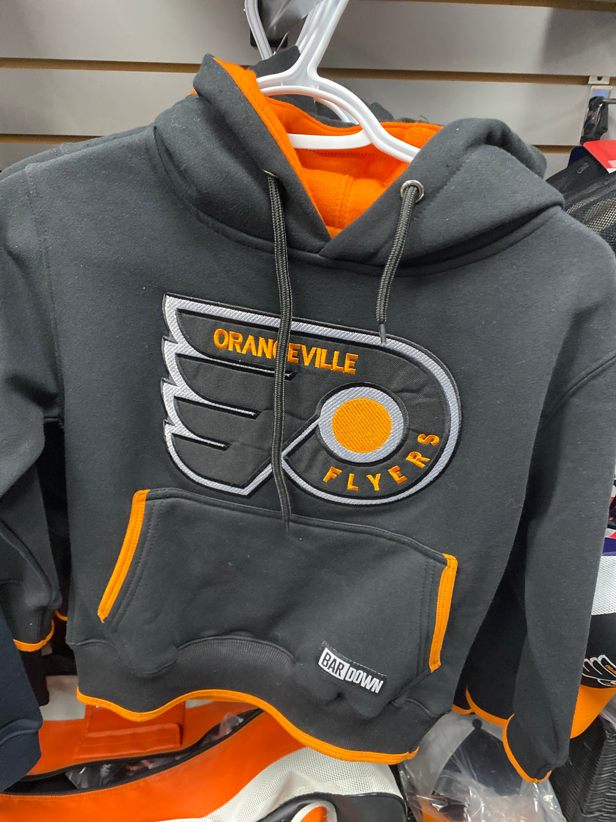The Bardown Orangeville Flyers Black with Orange Hoodie Youth by Sanderson Lacrosse features the team logo and a Bar Down label—perfect for young Flyers fans.