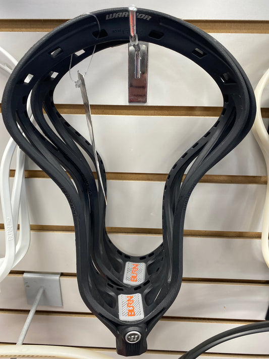 A black Sanderson Lacrosse Warrior Burn XP–O Lacrosse Head Unstrung with tags hangs on a slatwall, two silver stickers with the Warrior logo inside the pocket area.