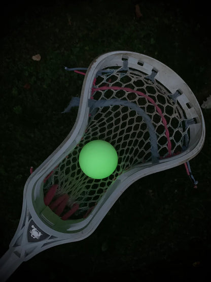 The Firefly Glow in the Dark Lacrosse Balls 3-pack, including a black light flashlight, from Firefly shines vividly in your lacrosse stick—perfect for nighttime games and easy visibility on dark fields.