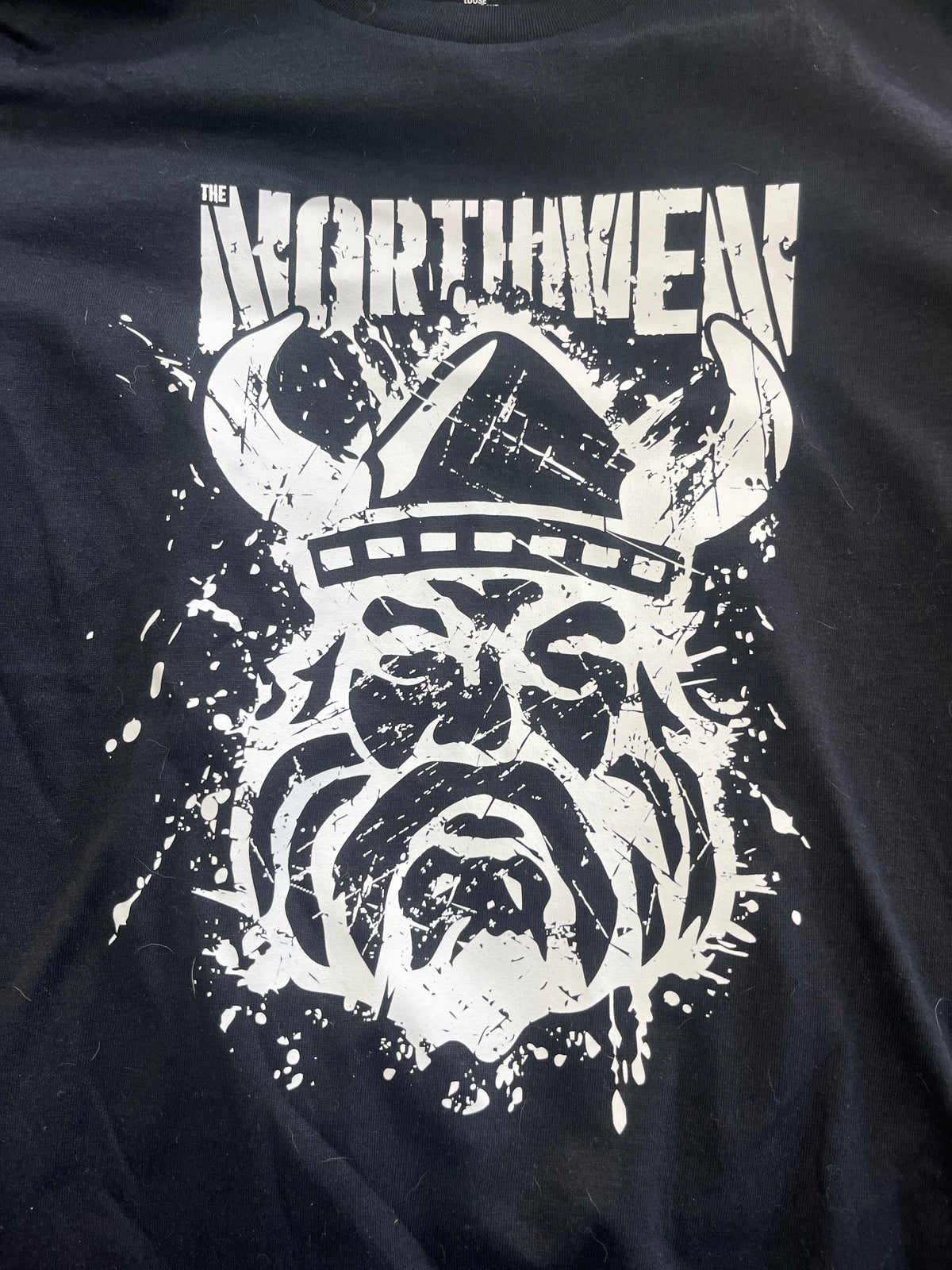Black t-shirt with white graphic design of a helmet and text on a dark background