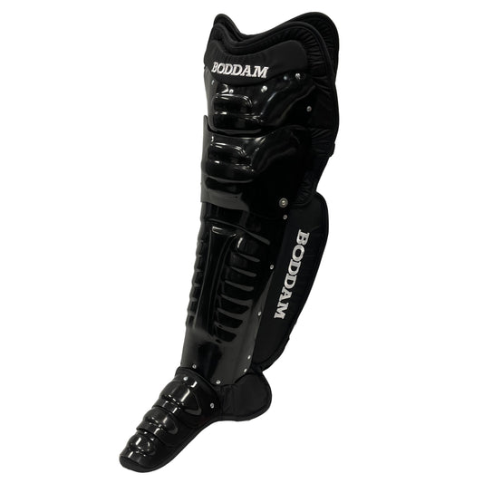 The Boddam Lacrosse Goalie Leg Pads feature a black, glossy, segmented design with white Boddam branding on the shin and calf. These protective pads cover foot to knee—ideal for box lacrosse goalies.