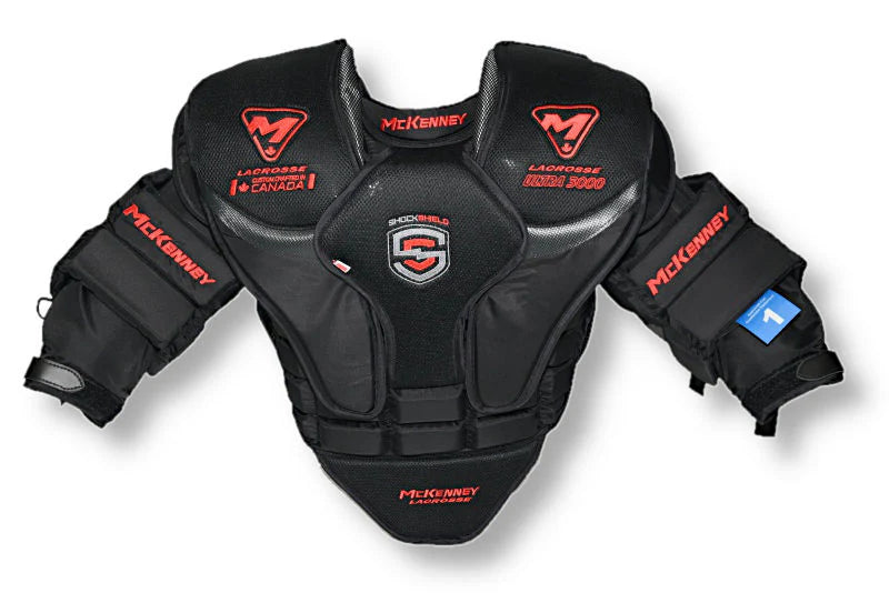 The McKenney Ultra 3000 Cat 1 Lacrosse Goalie Uppers feature black chest and arm protection, red and white McKenney logos, and thick padding on shoulders, arms, and chest for maximum coverage. Professional fit with Lacrosse branding.