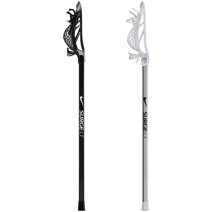 Two Nike Surge LT Complete Attack Lacrosse Sticks—one black, one white—stand upright with white netting. Ideal for beginners, each features “NIKE SURGE II” on the shaft and highlights Nike's trusted quality.