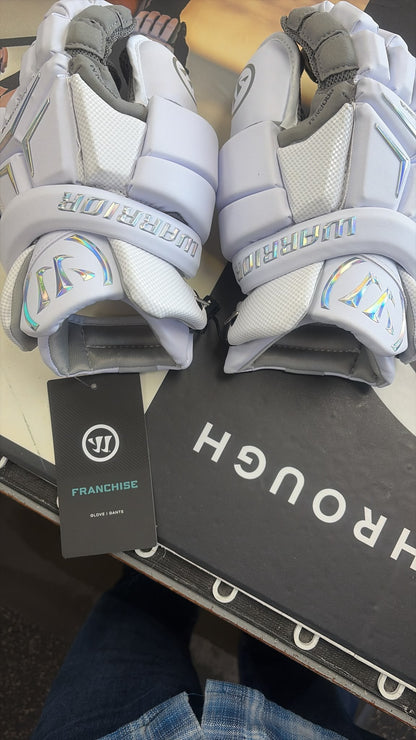 Pair of white Warrior Franchise 2026 field goalie gloves with holographic logos and Franchise hang tag at Sanderson Lacrosse in Orangeville